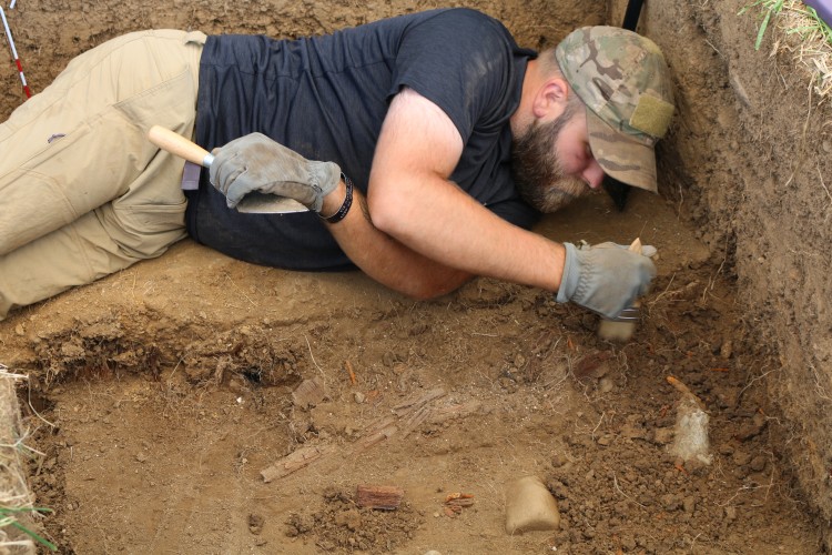 Cody Peak, a student from Western Oregon University, excavates a section of the privy.