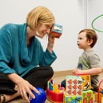 A child and an adult playing with toys.