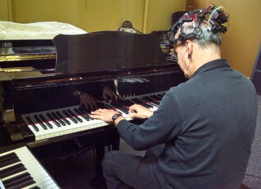 UW Music School Director Richard Karpen plays an electromagnetic piano called a Disklavier. Though he is shown performing on the keys, some of the music for the April 6 DXARTS Spring Concert will be played hands-free, with only the EEG.