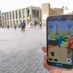 An app user holds up a phone with Kane Hall in the background