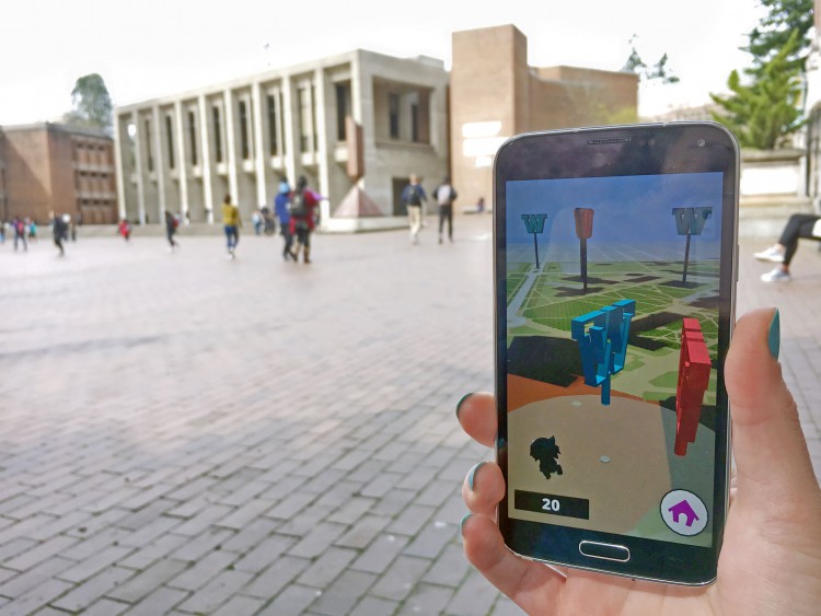An app user holds up a phone with Kane Hall in the background