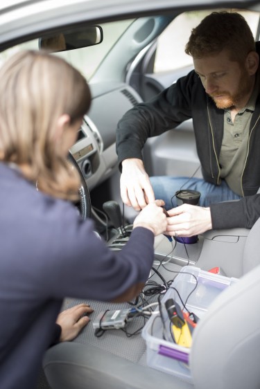 UW Security and Privacy Lab researchers Peter Ney (left) and Ian Smith (right) install a SeaGlass sensor in a test vehicle.