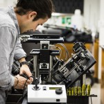 Photo of Adam Glaser tweaking microscope