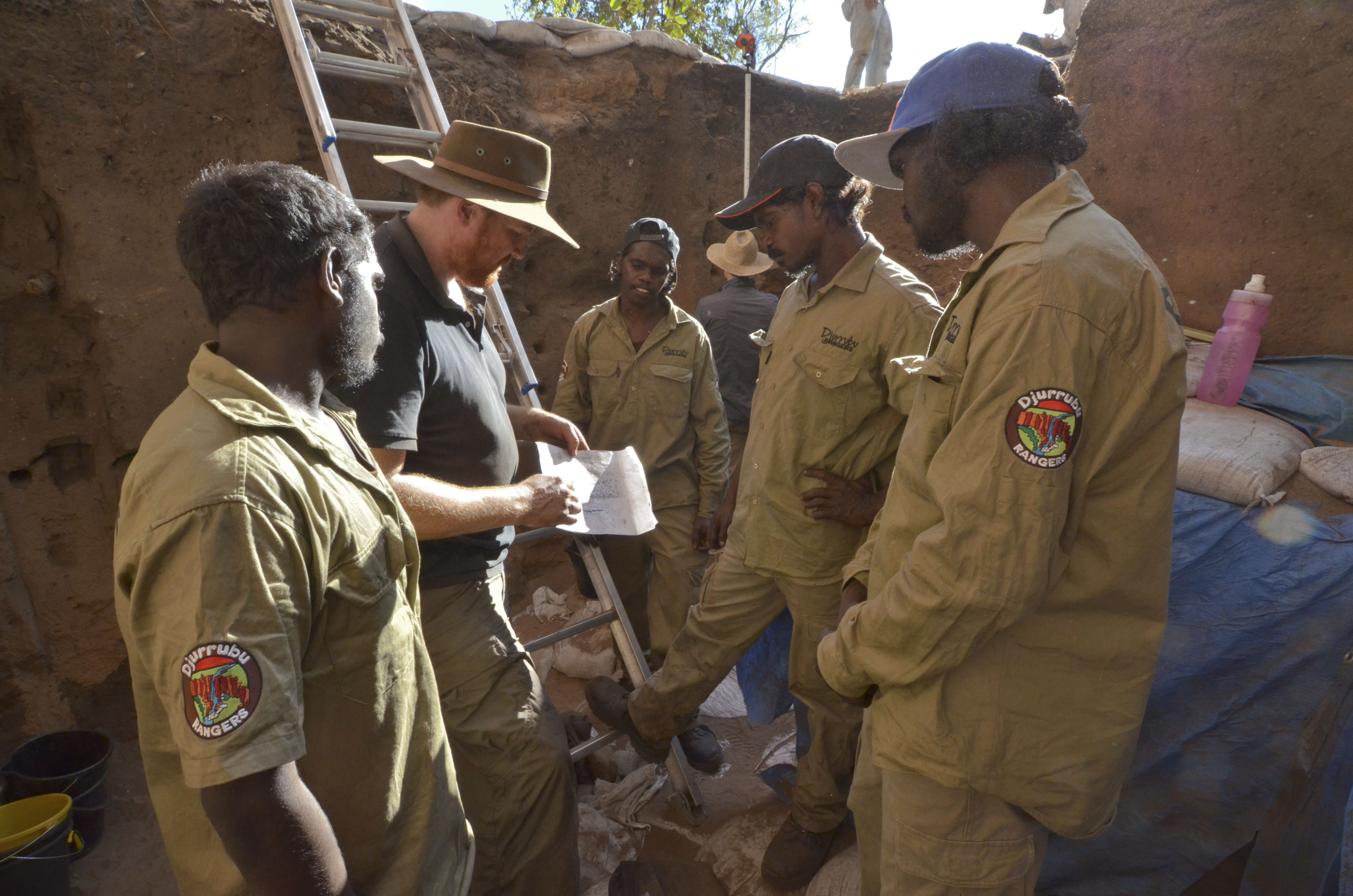 Chris Clarkson of the University of Queensland talks with Djurrubu Aboriginal Rangers Vernon Hardy Mitchum Nango, Jacob Baird, Claude Hardy at the excavation site in Australia's Northern Territory. University of Washington researchers were part of the team that dated artifacts from the site.