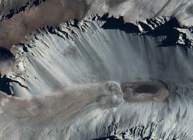 aerial image of dark spot in white valley