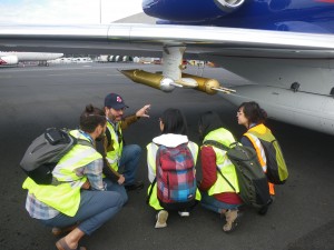 people under aircraft wing