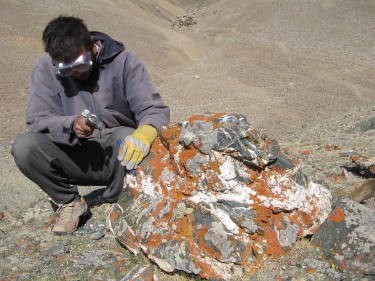 person with hammer and red rock