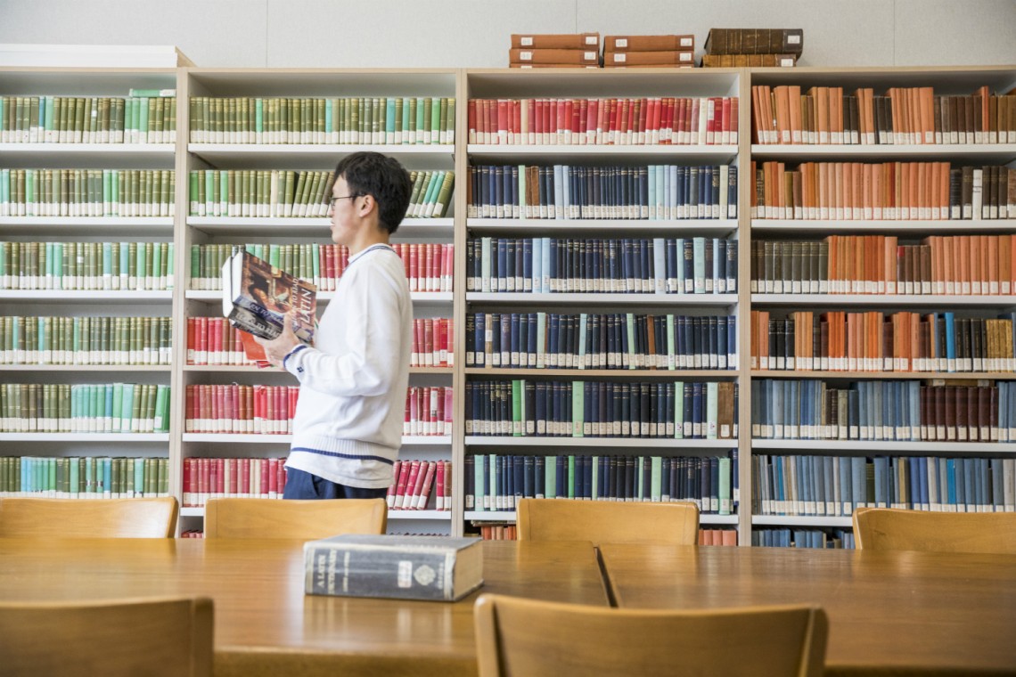 Project SEARCH intern Alan Chen helps organize the library in the Department of Classics in Denny Hall. The books had been boxed up during the Denny renovation, and with Chen's help, "The collection is in the best shape it's been in since we moved," said Doug Machle, assistant to the department chair. Project SEARCH is a program that provides job experience to young adults with autism.