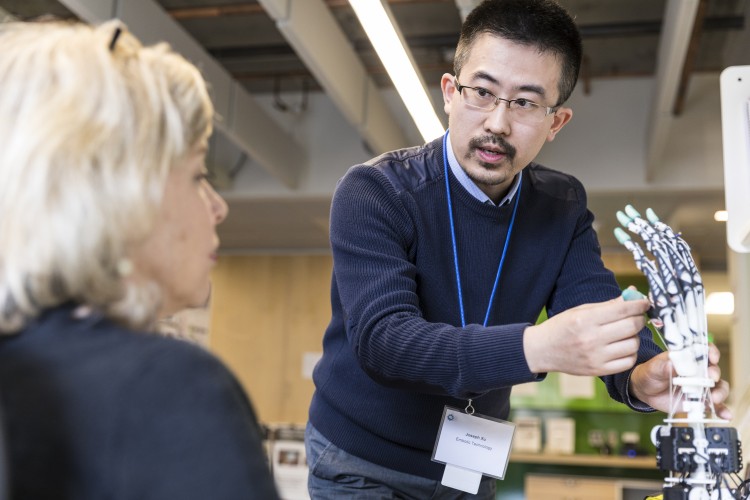 demonstrating a robotic, biomimetic hand to a center visitor