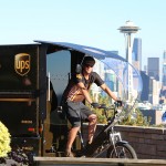 A UPS delivery person on an e-bike in front of the Space Needle