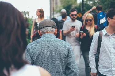 People walking in a crowd, looking at their phones.