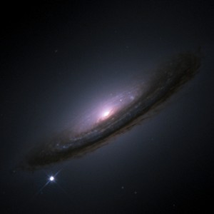 An image of a galaxy in outer space, with a bright supernova visible at its outer edge.