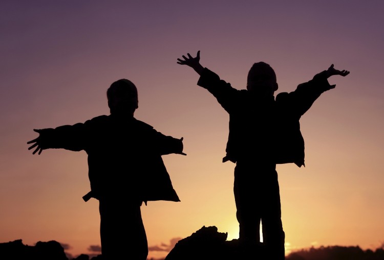 A University of Washington-led study finds that children who socially transition to the gender "opposite" their sex at birth also demonstrate strong "cross-gender" identities before the transition. Photo of two children in silhouette.
