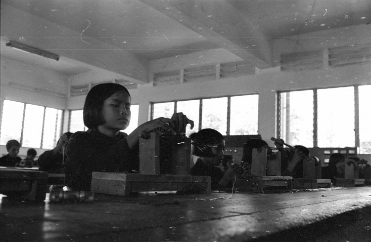 This is one of dozens of photographs of Cambodian citizens, taken by journalist and UW alum Elizabeth Becker on her tour of the country in 1978. Photo of young girl in a factory