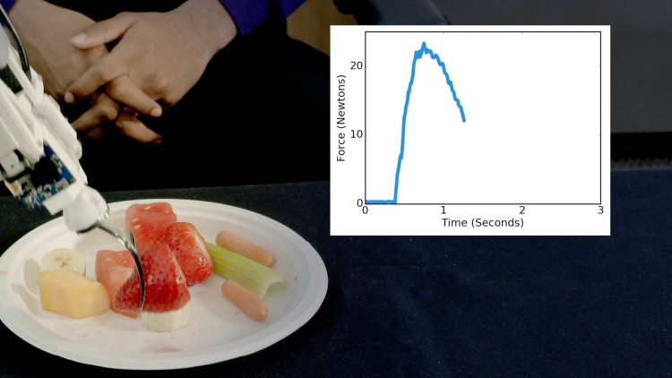 The robot skewers a strawberry