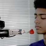 A robot feeds a volunteer a strawberry