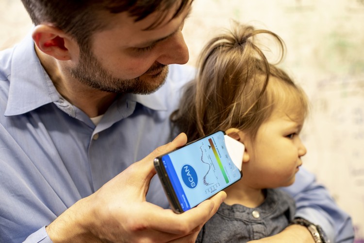 A doctor uses the app to check his daughter's ear