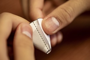 hands folding a taping a piece of paper into a funnel shape