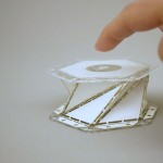 a hand pointing to the paper model