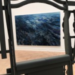 "Spoiled Landscapes - Ocean," an oil on canvas by Baorong Liang is seen through a gap in Brighton McCormack's house-like structure "Fully Furnished" (in video above) at the 2019 MFA + MDes Thesis Exhibition at the Henry Art Gallery.