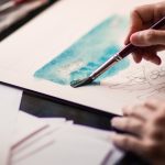 hands paining with watercolors