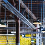 A factory ceiling with low hanging lights