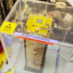 tall silver rectangle inside glass box that reads "flight hardware"