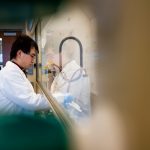 A researcher works in a chemical hood