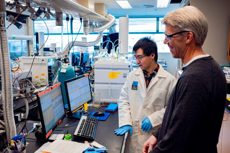 Two researchers looking at a computer screen in a lab