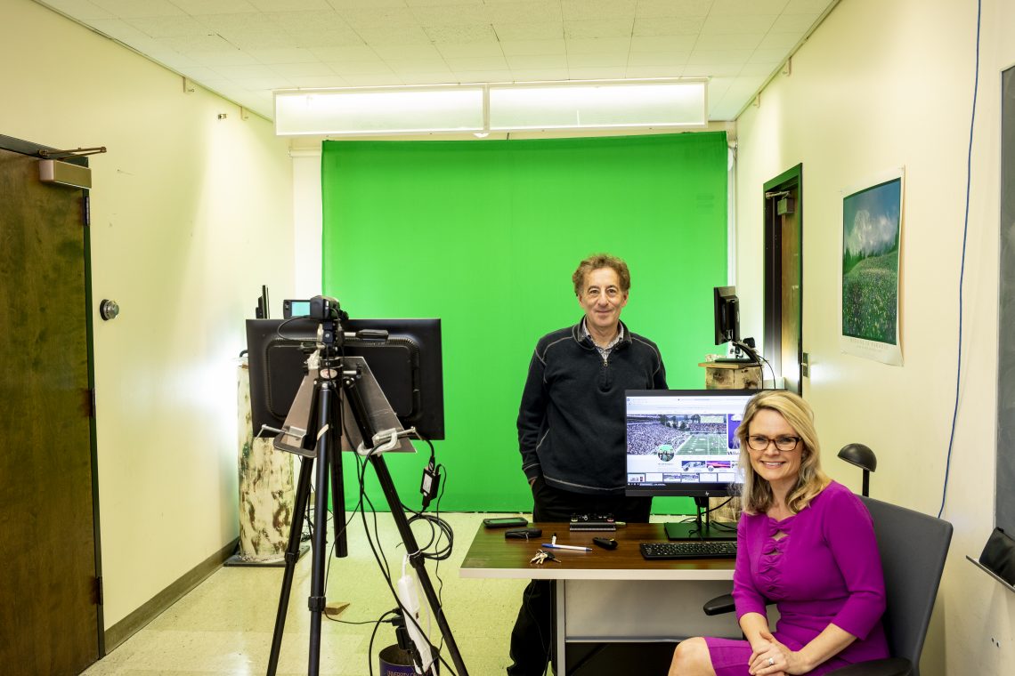 two people in front of green screen