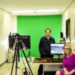 two people in front of green screen