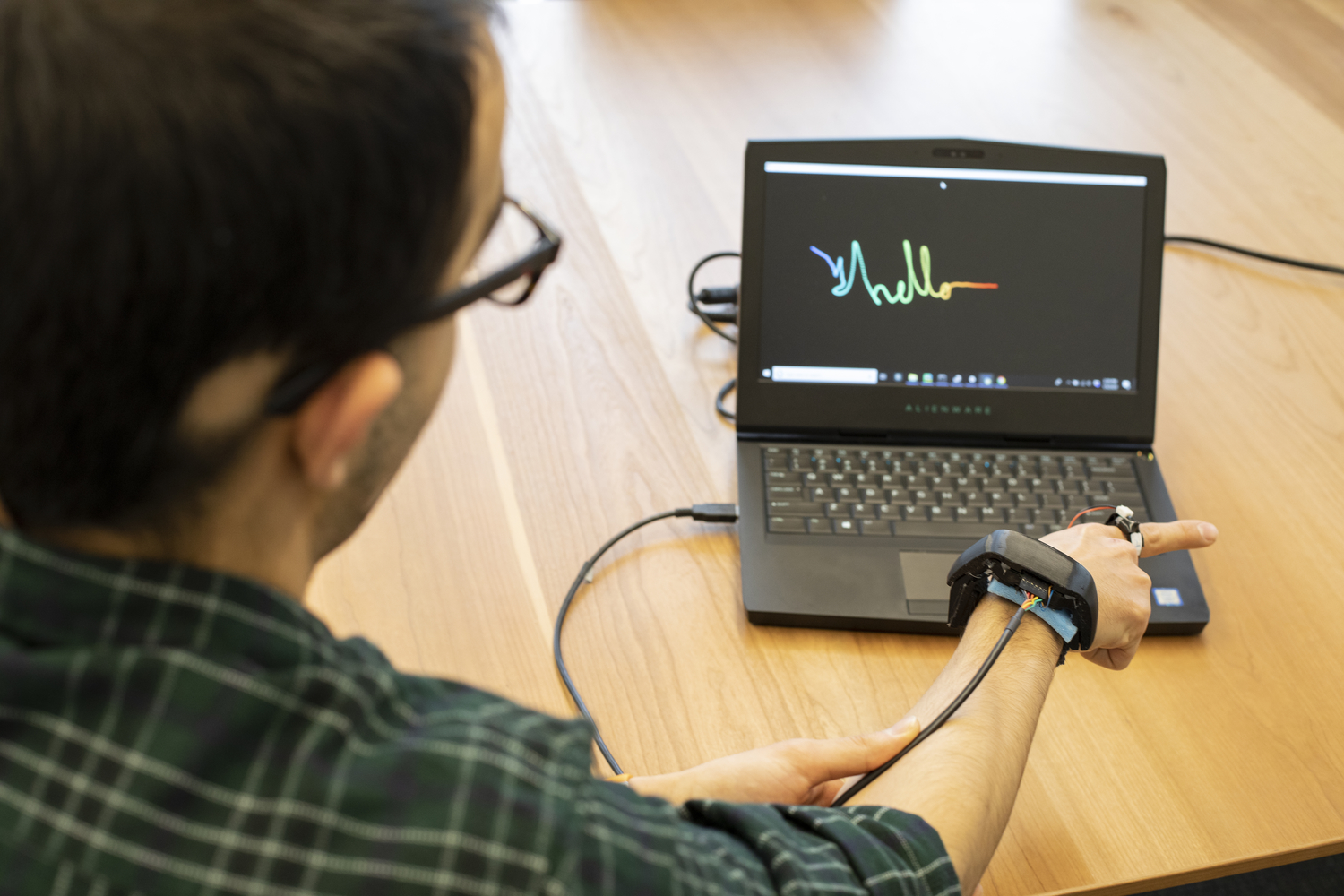 A researcher uses AuraRing to write 