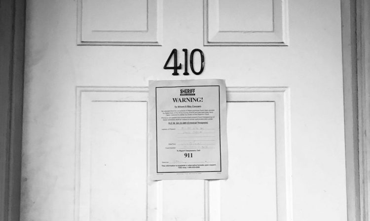 Photo of closed door with eviction notice on the front