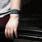 A close up of a hand holding oars. On the person's wrist is a fitness tracker