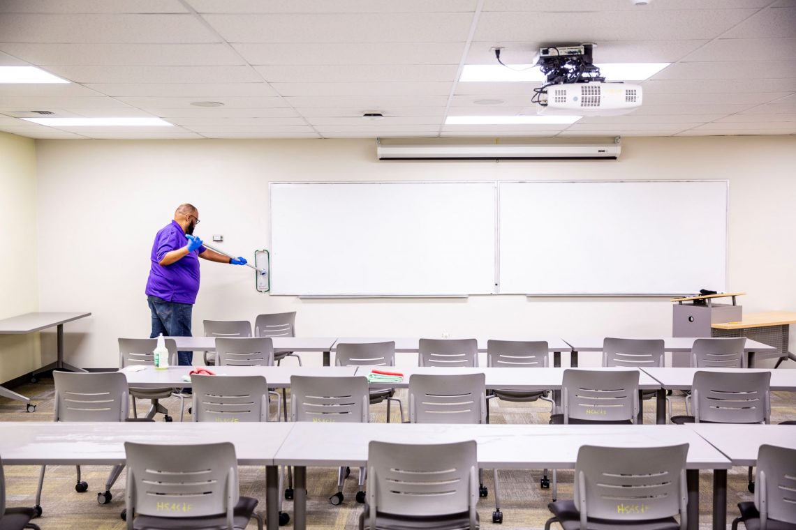 man in purple shirt scubs wall