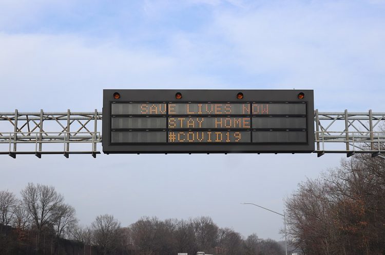 Digital sign says Save Lives Now Stay Home COVID-19
