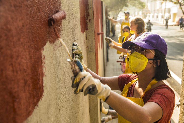 Students painting a wall a copper color