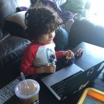 A child in front of a laptop.