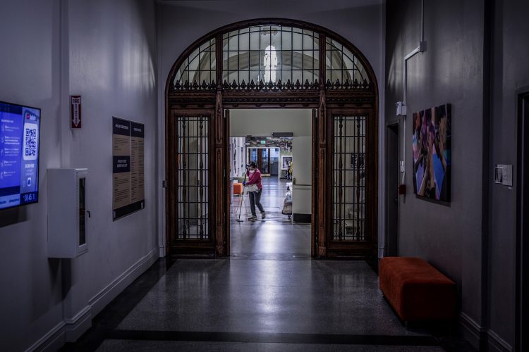 person mops floor in a dimly lit building