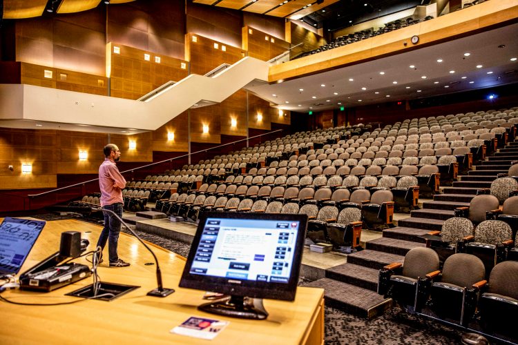 man on stage in empty auditorium