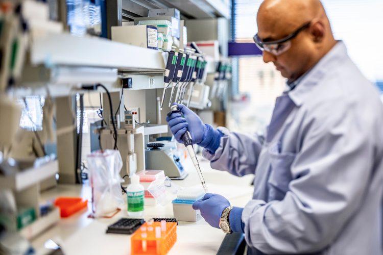 man using a pipette in a lab