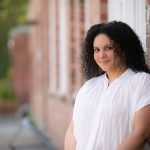 Woman standing against outside of law school building