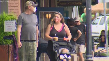 people wearing masks on city sidewalk