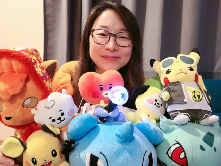 A portrait of a researcher surrounded by stuffed Pokémon