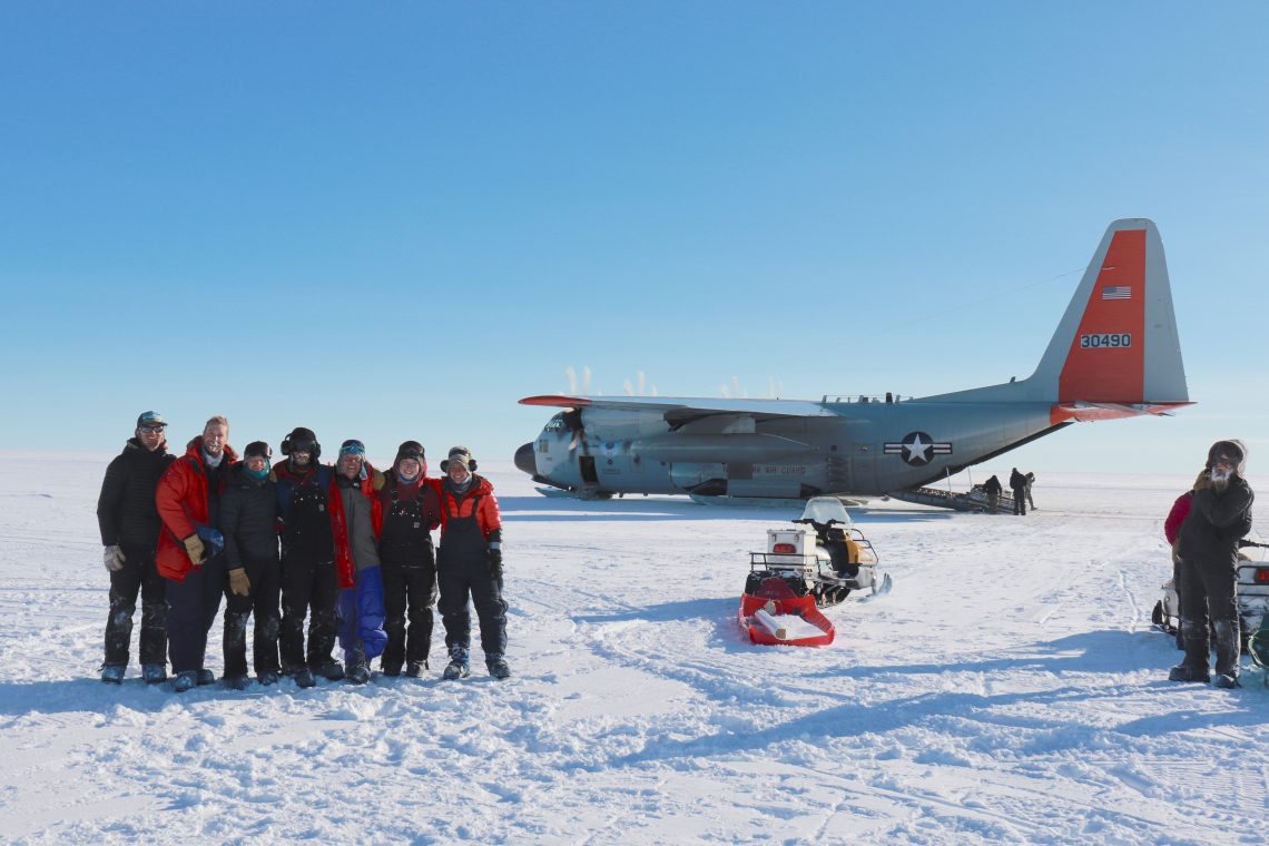 people on snow in front of helicopter