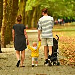 parents with young child walking in a park