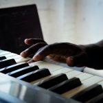 A hand pressing a piano key