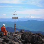 scientists in orange suits with mountains in distance