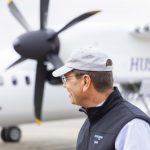 Brad Tilden, a UW alum who retired as CEO of Alaska Airlines on March 31, looks at a Horizon Air Q400 aircraft with a special UW-themed livery.