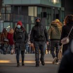 Masked people walking on a city street.